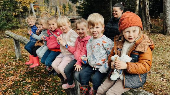 children sitting on a wooden fence