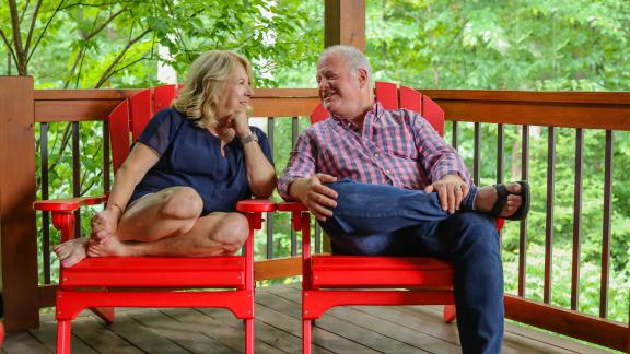 couple sitting on Adirondack chairs