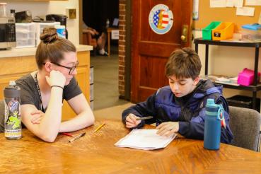 Woman helping teen with homework